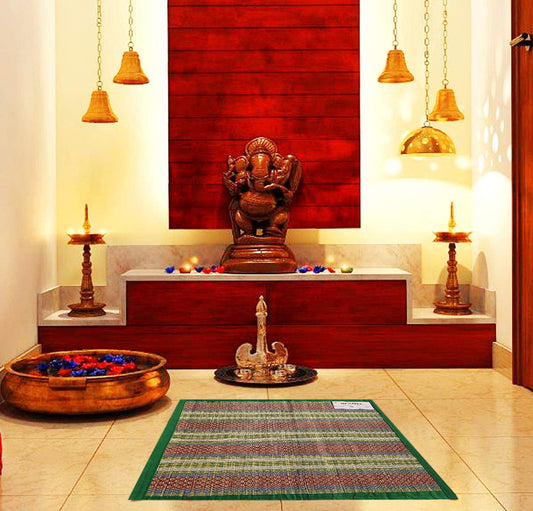 Madurkathi pooja aasan with border design placed on a traditional Indian rug